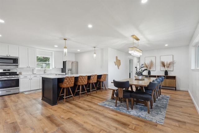 dining room with light hardwood / wood-style flooring and a notable chandelier