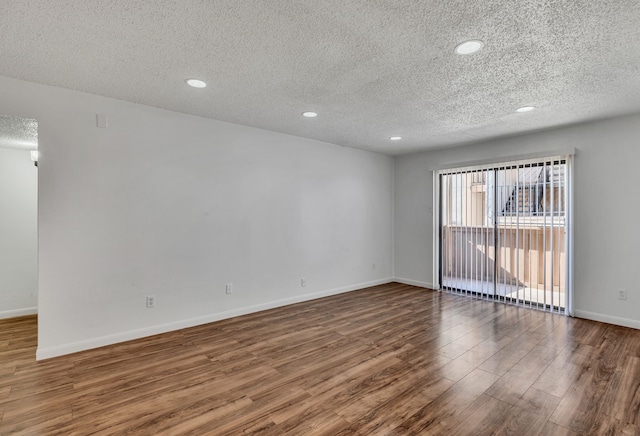 spare room featuring a textured ceiling and hardwood / wood-style flooring