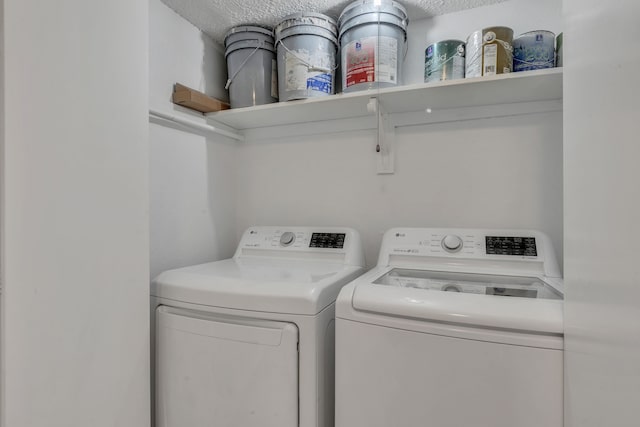 clothes washing area featuring a textured ceiling and washing machine and dryer