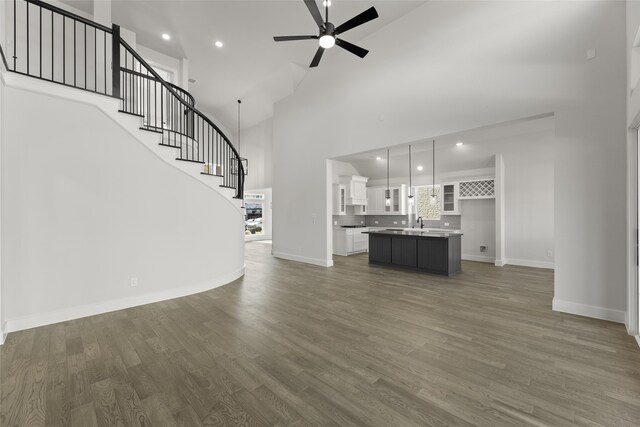 2614 Shadybrook Dr, Celina, TX 75009 - unfurnished living room featuring a towering ceiling, wood finished floors, baseboards, and a ceiling fan