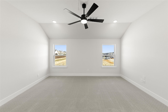 carpeted spare room featuring ceiling fan, a healthy amount of sunlight, and vaulted ceiling