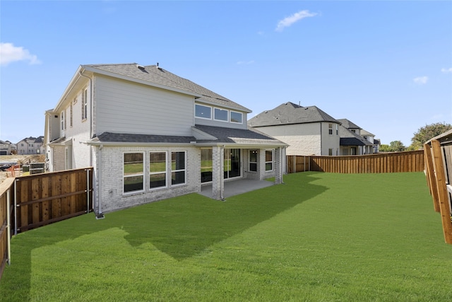 rear view of house featuring a patio and a yard