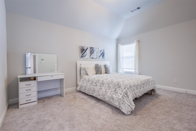 bedroom with lofted ceiling and light carpet