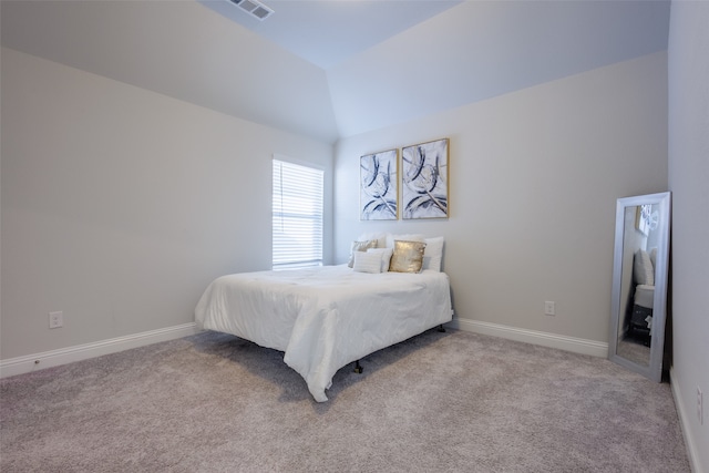 bedroom featuring lofted ceiling and light carpet