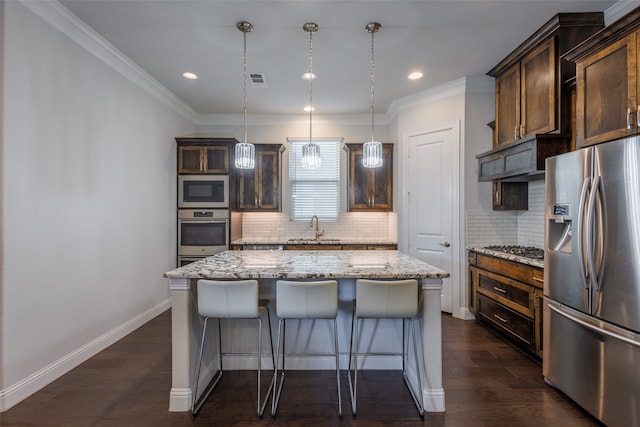 kitchen featuring a center island, stainless steel appliances, sink, dark hardwood / wood-style flooring, and pendant lighting