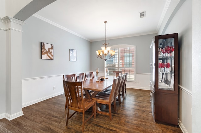 dining area featuring crown molding, dark hardwood / wood-style floors, a chandelier, and decorative columns