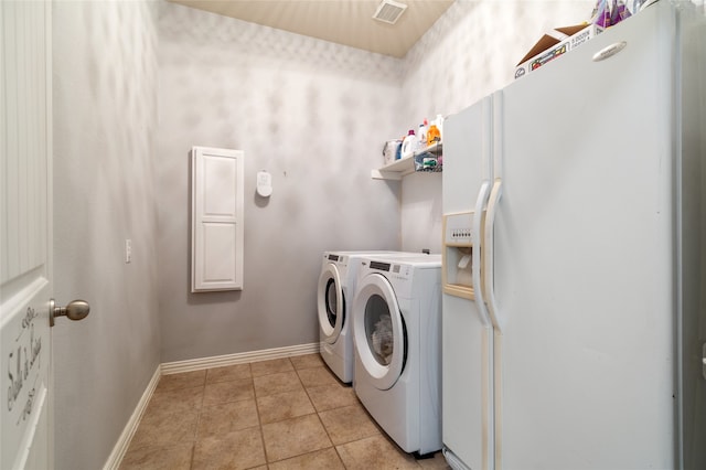 laundry room with light tile patterned floors and separate washer and dryer