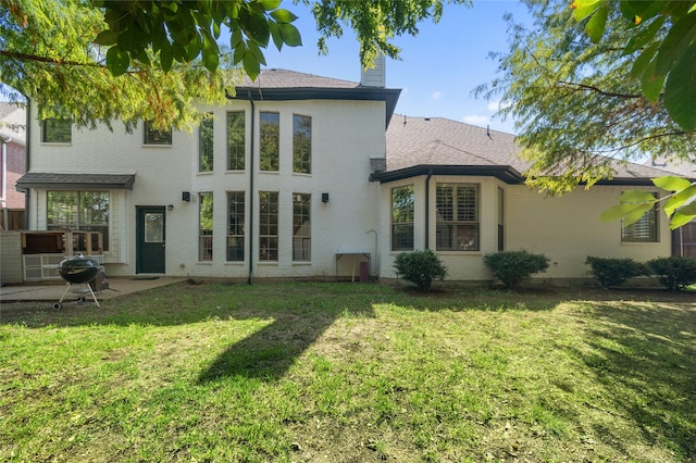 rear view of property with a yard and a patio