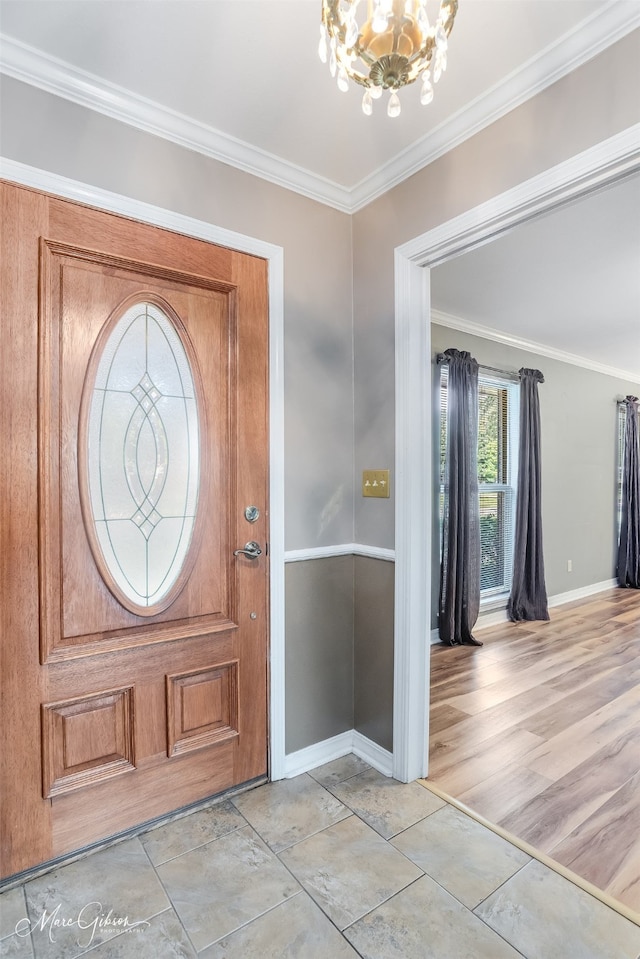 foyer featuring a notable chandelier, light wood-type flooring, and crown molding