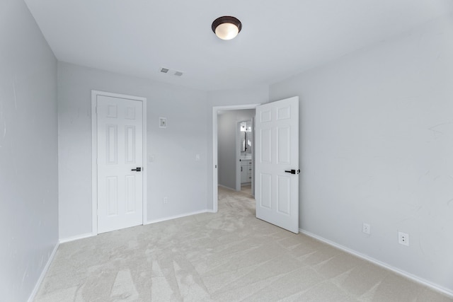 unfurnished bedroom featuring light carpet and a closet