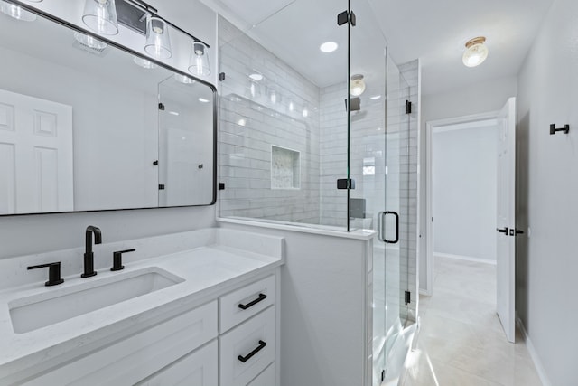 bathroom featuring vanity, a shower with shower door, and tile patterned floors