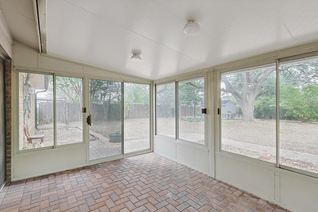 unfurnished sunroom with lofted ceiling