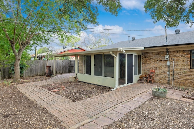 rear view of property featuring a patio area and a sunroom