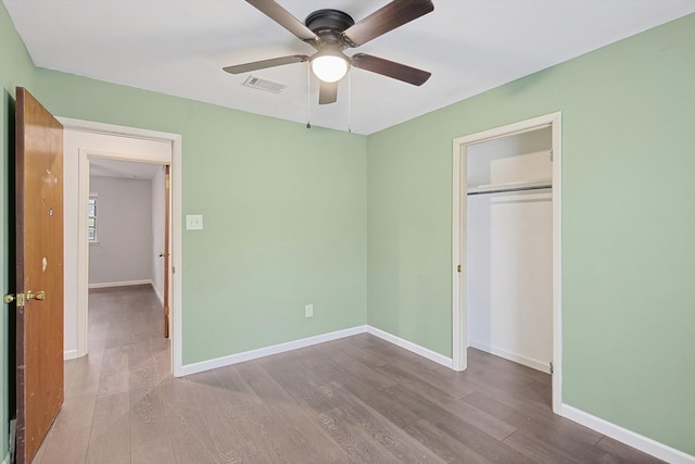 unfurnished bedroom featuring light hardwood / wood-style floors, ceiling fan, and a closet