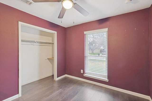 unfurnished bedroom with ceiling fan, a closet, and wood-type flooring