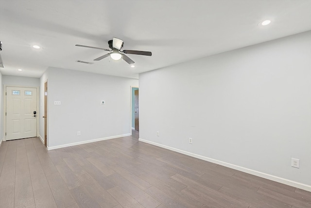 empty room with ceiling fan and light hardwood / wood-style flooring