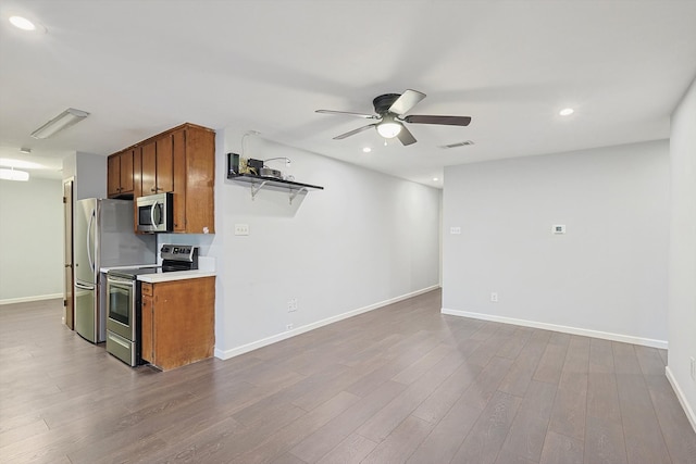 kitchen with wood-type flooring, ceiling fan, and stainless steel appliances