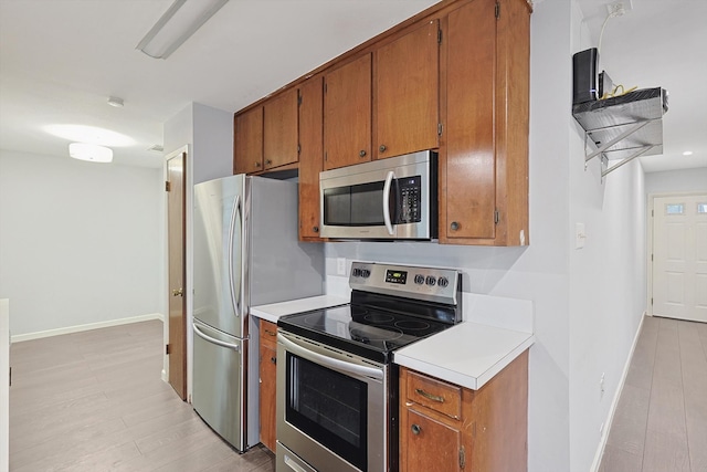 kitchen featuring stainless steel appliances and light hardwood / wood-style flooring