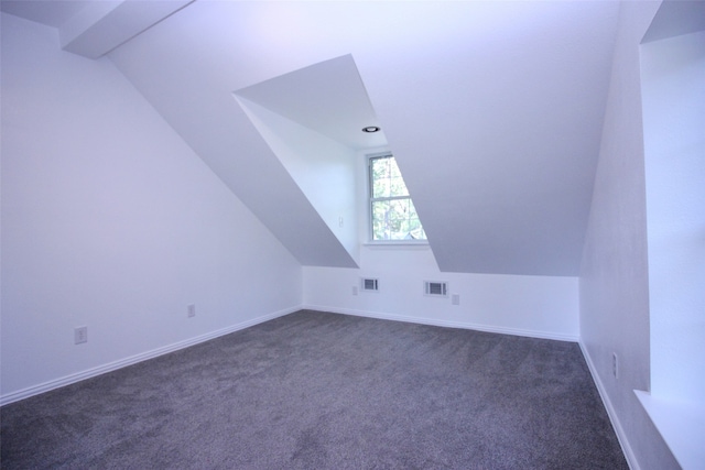 bonus room featuring lofted ceiling with beams and dark colored carpet