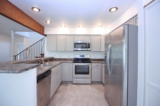 kitchen with kitchen peninsula, appliances with stainless steel finishes, and sink