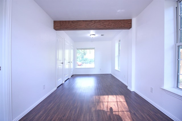 unfurnished room featuring beamed ceiling and dark wood-type flooring