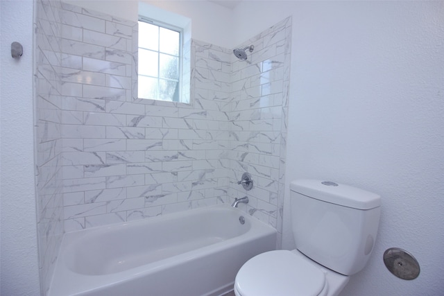 bathroom featuring toilet and tiled shower / bath combo