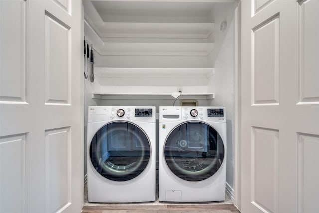 laundry room with wood-type flooring and washing machine and clothes dryer