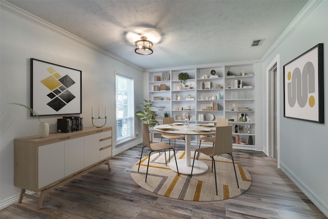 dining room featuring dark hardwood / wood-style flooring, a textured ceiling, and ornamental molding