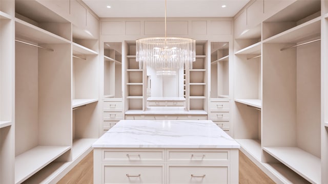 walk in closet with an inviting chandelier