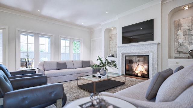 living room featuring crown molding and a high end fireplace