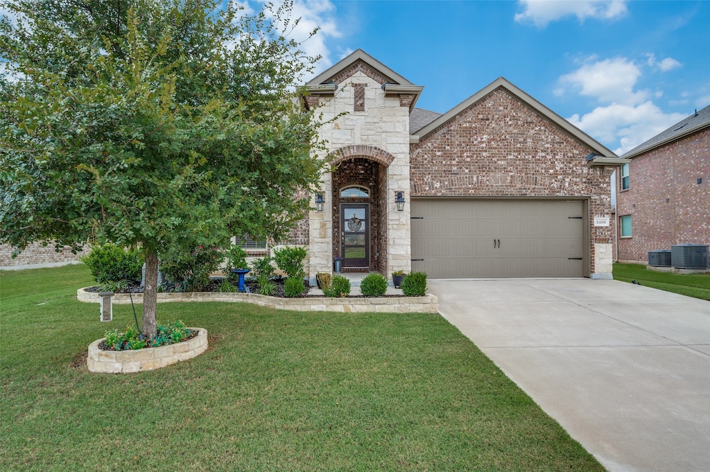 view of front of house with a front yard, a garage, and central air condition unit