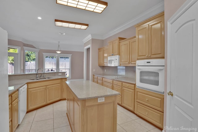 kitchen with white appliances, sink, a center island, crown molding, and light brown cabinets