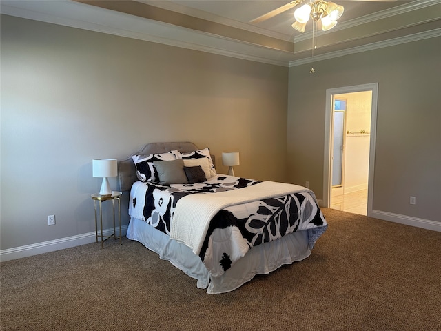 bedroom featuring light carpet, a tray ceiling, crown molding, ensuite bathroom, and ceiling fan