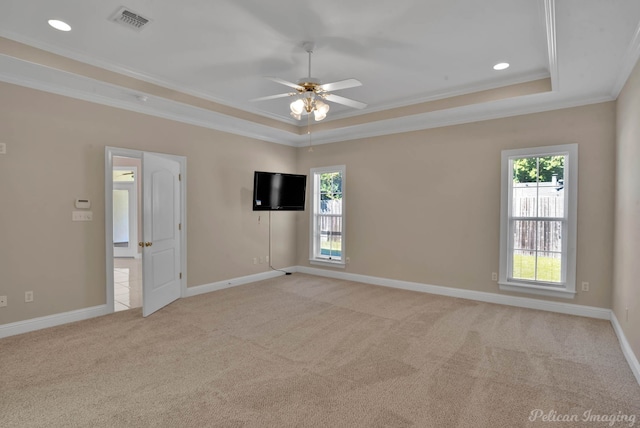 spare room featuring ceiling fan, a raised ceiling, ornamental molding, and light colored carpet