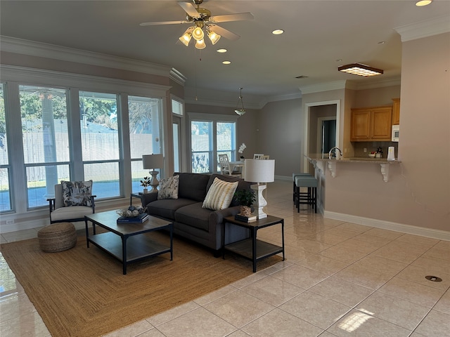 tiled living room with ornamental molding, sink, and ceiling fan