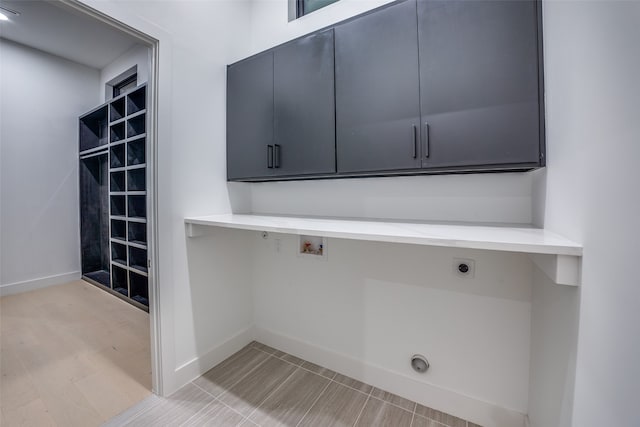 clothes washing area featuring washer hookup, cabinets, light hardwood / wood-style flooring, and hookup for an electric dryer