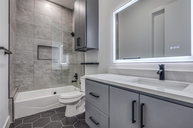 full bathroom featuring tiled shower / bath, vanity, toilet, and tile patterned floors