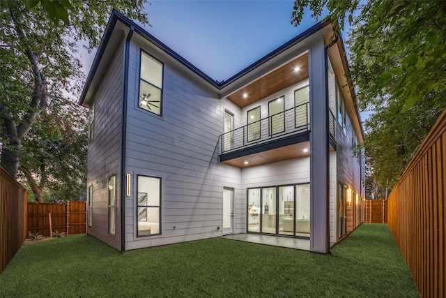 rear view of property with a yard and a balcony