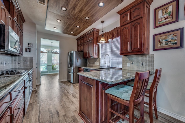 232 Touchdown Dr, Irving, TX 75063 - kitchen with stainless steel appliances, a sink, wood finished floors, light stone countertops, and tasteful backsplash