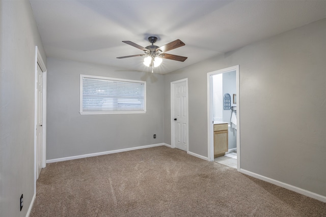 unfurnished bedroom with light colored carpet, ceiling fan, and ensuite bathroom