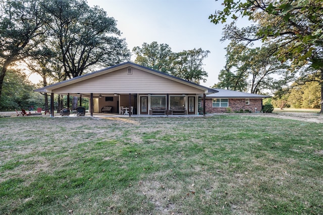 rear view of house with a lawn and a patio