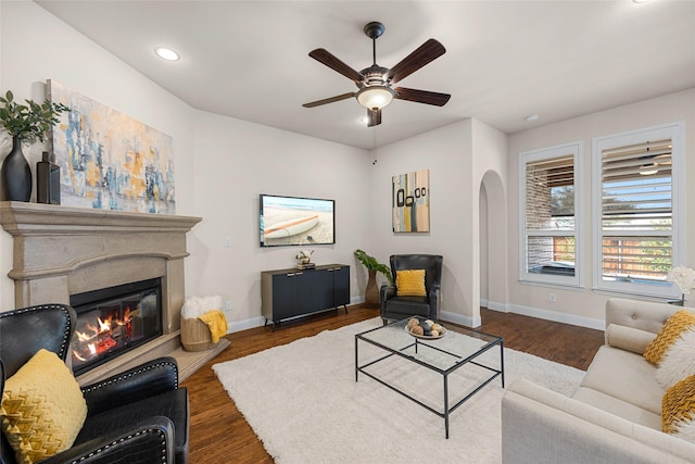 living room with dark wood-type flooring and ceiling fan