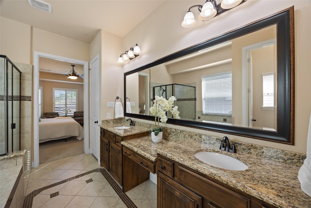 bathroom with ceiling fan, vanity, a shower with door, and tile patterned flooring