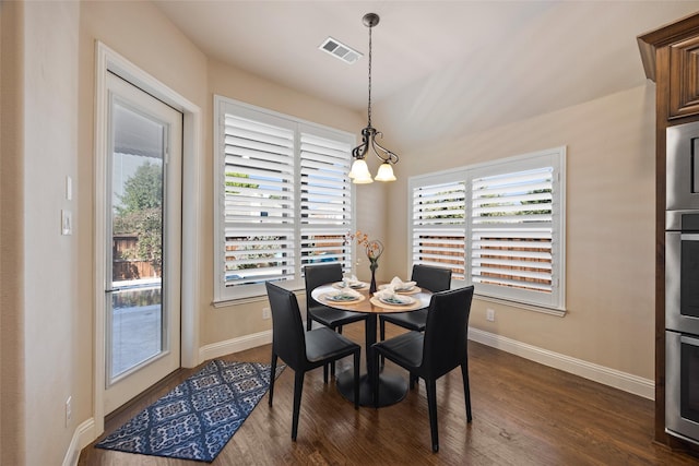 dining area with an inviting chandelier and dark wood-type flooring