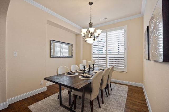 dining area with an inviting chandelier, ornamental molding, and dark hardwood / wood-style flooring