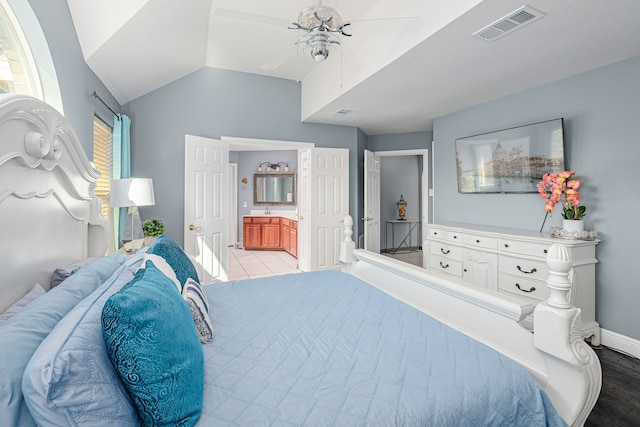 bedroom with vaulted ceiling, hardwood / wood-style floors, ensuite bathroom, and ceiling fan