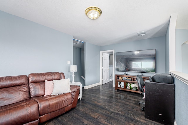 living room featuring dark hardwood / wood-style flooring and a textured ceiling