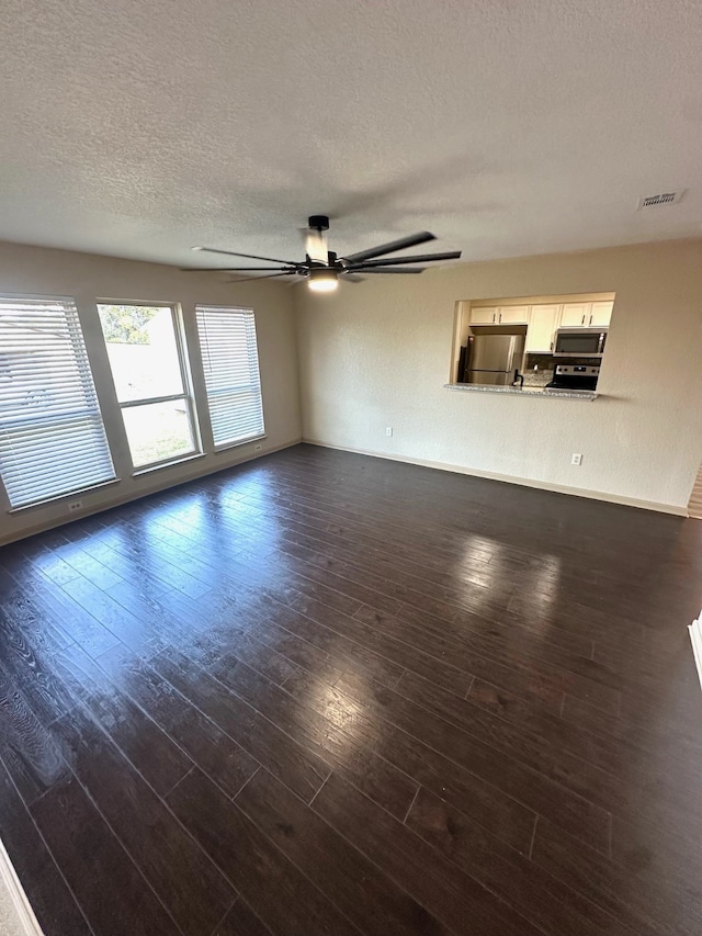 empty room featuring ceiling fan, dark hardwood / wood-style floors, and a textured ceiling