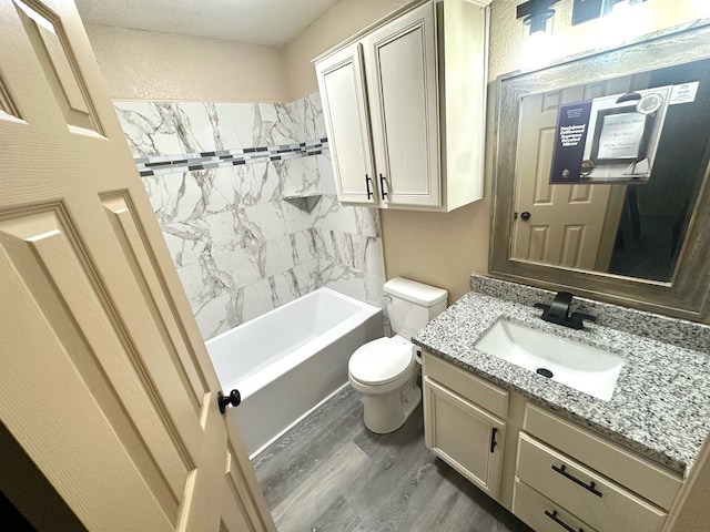 full bathroom featuring wood-type flooring, tiled shower / bath, vanity, and toilet