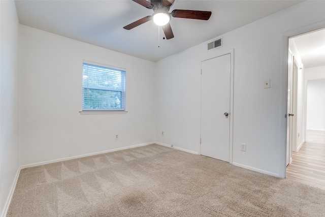 carpeted spare room with ceiling fan